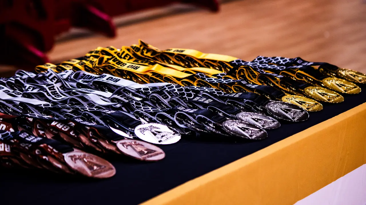 Rows of RGV Open gold, silver and bronze medals laid out on a table.